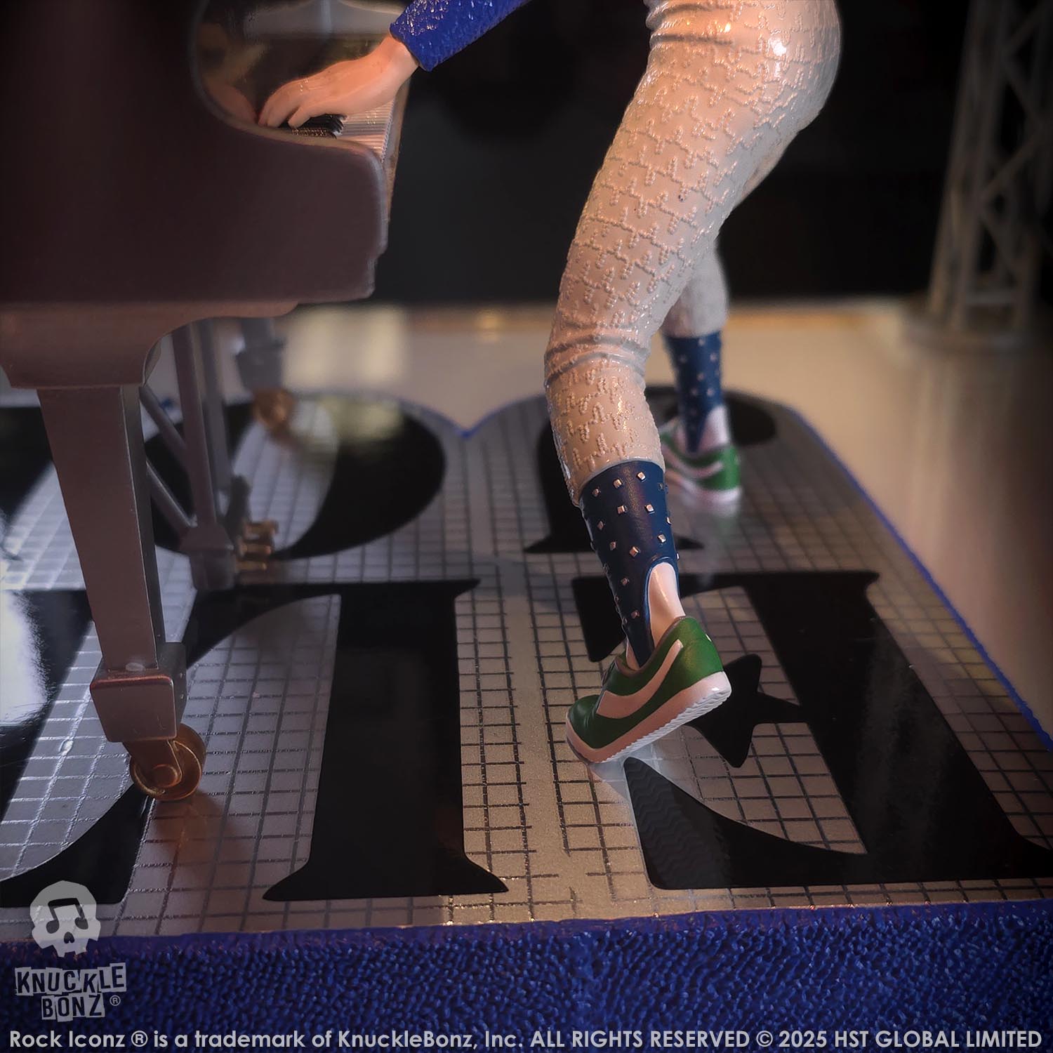 Statue of Elton John with a grand piano in a baseball uniform with a dark background